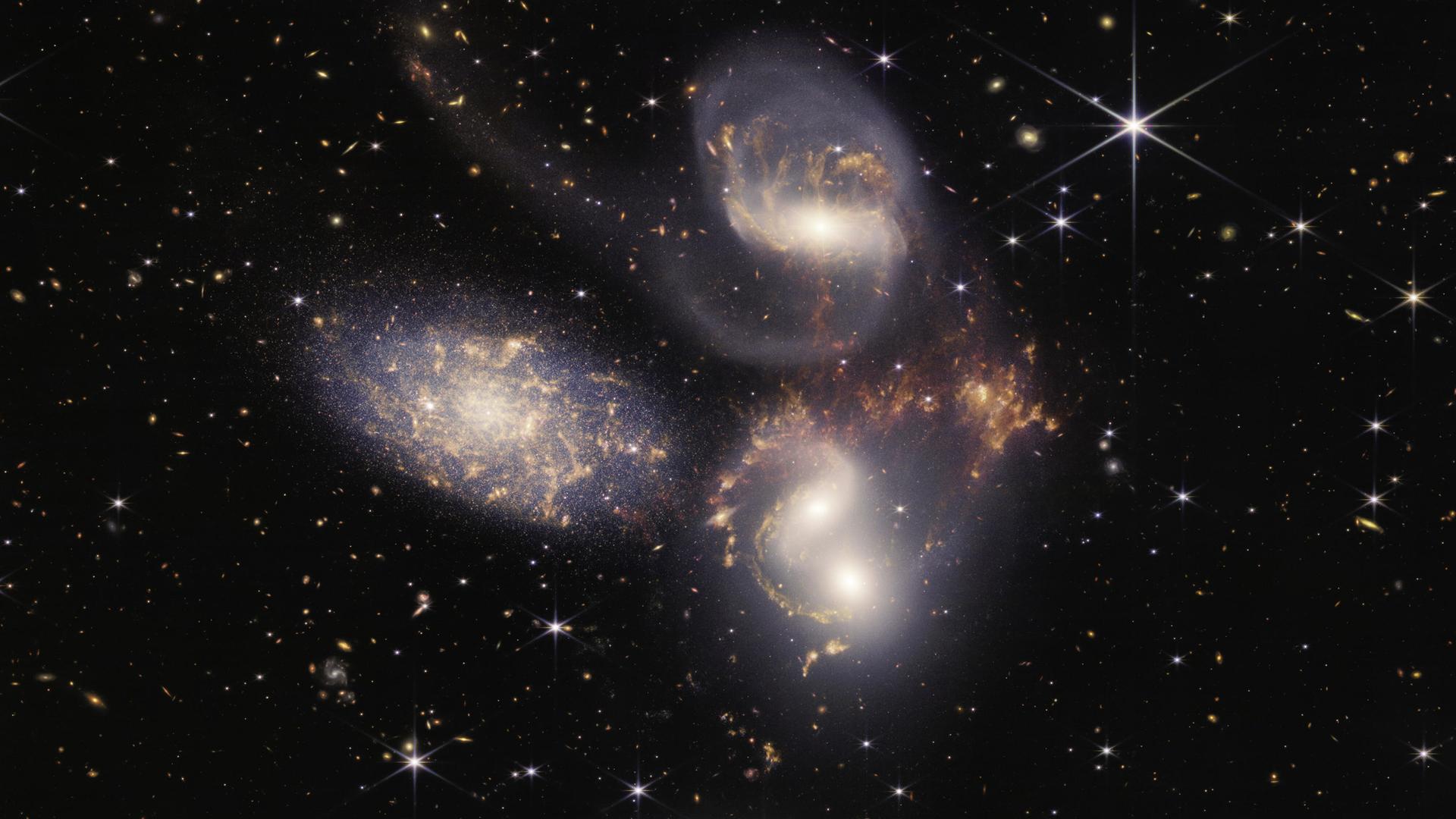 Das James-Webb-Weltraum-Teleskop zeigt einen tiefen Einblick ins Weltall. Einzelne Körper leuchten vor einem tiefen schwarzen Hintergrund.