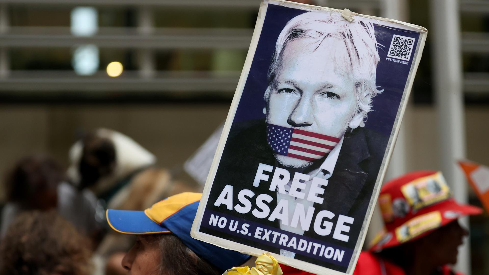 Ein Demonstrant hält ein Schild mit der Forderung "Free Assange - No Extradiction" hoch. Ein Demonstrant hält ein Schild mit der Forderung "Free Assange - No Extradiction" hoch.