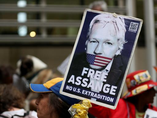 Ein Demonstrant hält ein Schild mit der Forderung "Free Assange - No Extradiction" hoch.