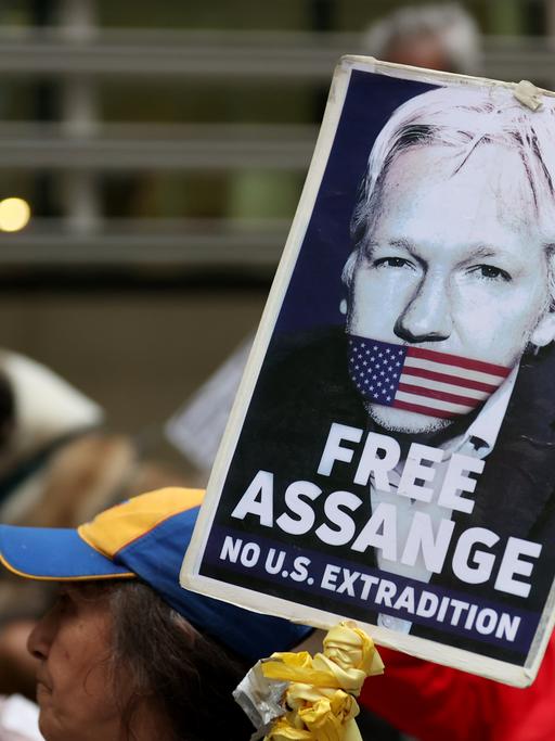 Ein Demonstrant hält ein Schild mit der Forderung "Free Assange - No Extradiction" hoch.
