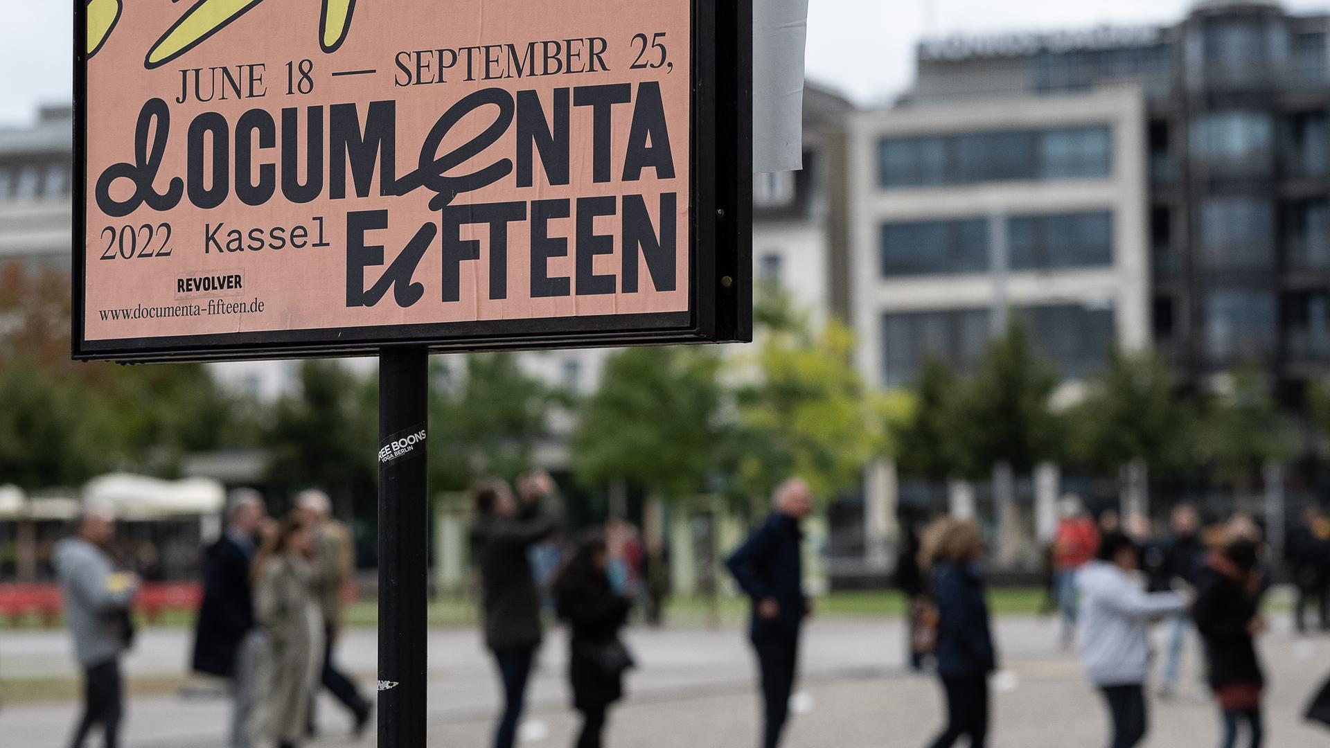 Besucher stehen hinter einem Veranstaltungsplakat am Eingang zum Museum Fridericianum in einer Schlange. Besucher stehen hinter einem Veranstaltungsplakat am Eingang zum Museum Fridericianum in einer Schlange.