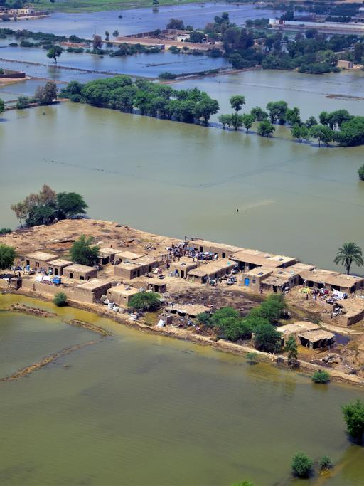 Die Landschaft in Jaffarabad, einem Bezirk der südwestlichen pakistanischen Provinz Belutschistan, ist großflächig unter Wasser. Einzelne Häuser sind von den Fluten umgeben. Das Foto wurde am 3. September 2022 aufgenommen.