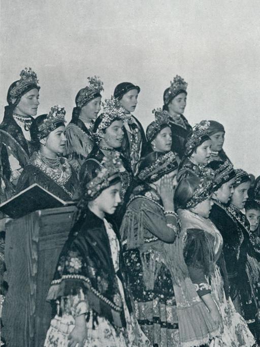 Eine historische Fotografie zeigt ungarische Mädchen, die 1932 in ihren Trachten einen Chor bilden.