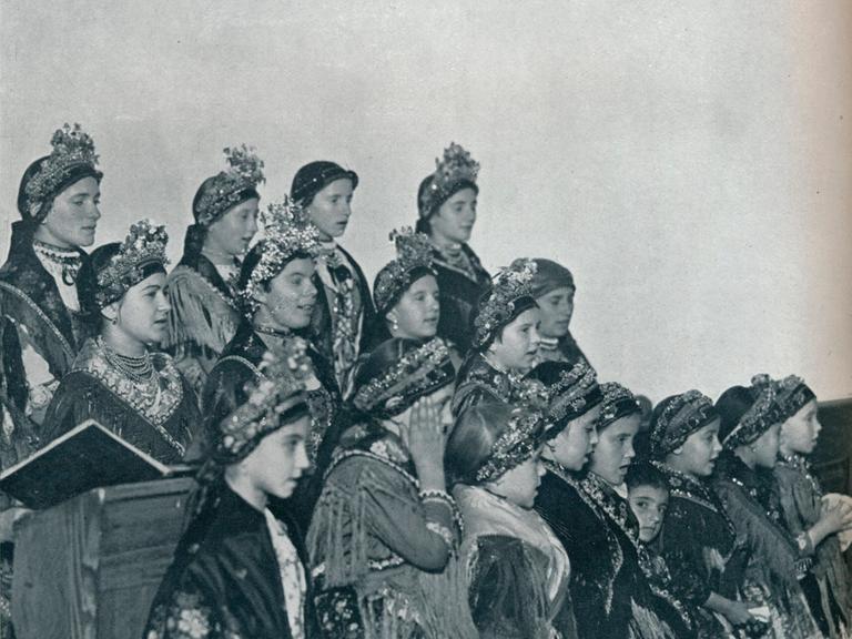 Eine historische Fotografie zeigt ungarische Mädchen, die 1932 in ihren Trachten einen Chor bilden.
