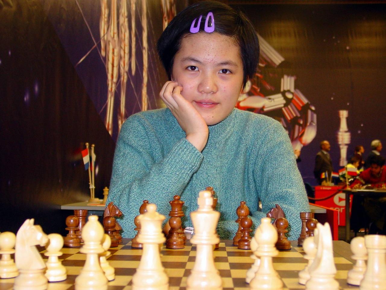 Hou Yifan 2007 beim Schachturnier in Wijk aan Zee mit in die Hand gestütztem Kopf vor einem Schachbrett sitzend