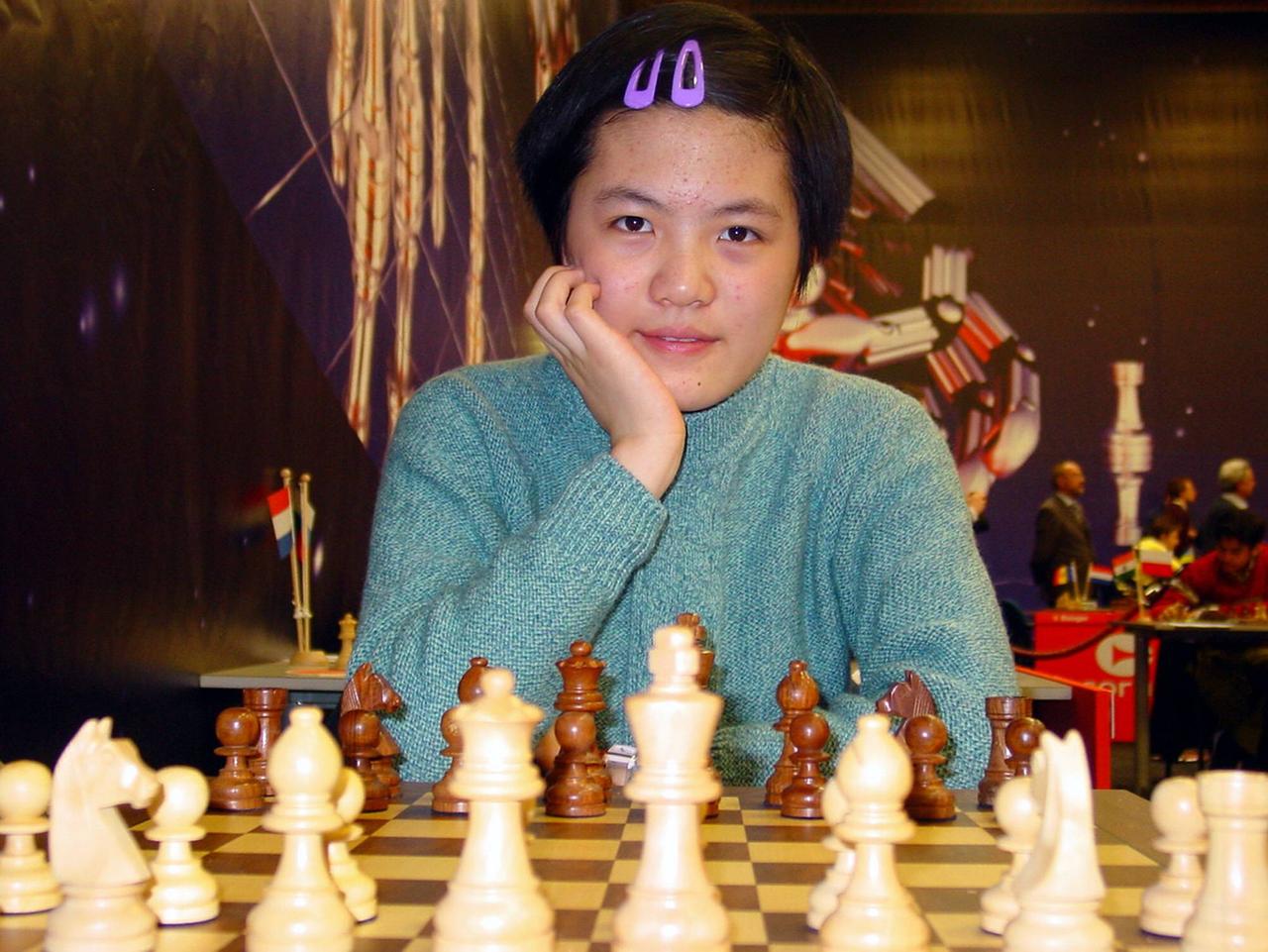 Hou Yifan 2007 beim Schachturnier in Wijk aan Zee mit in die Hand gestütztem Kopf vor einem Schachbrett sitzend Hou Yifan 2007 beim Schachturnier in Wijk aan Zee mit in die Hand gestütztem Kopf vor einem Schachbrett sitzend
