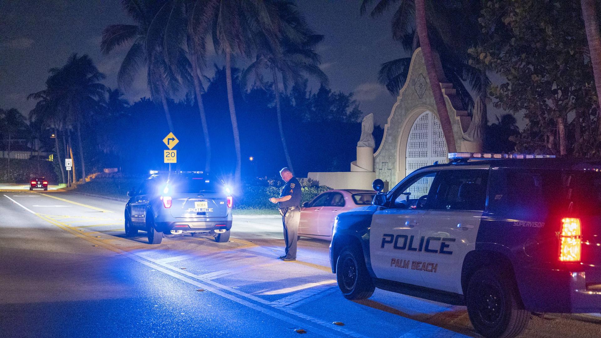 Zwei Polizei-Wagen stehen in der Nacht vor dem Haus Mar-A-Lago von Donald Trump in Florida. Zwei Polizei-Wagen stehen in der Nacht vor dem Haus Mar-A-Lago von Donald Trump in Florida.