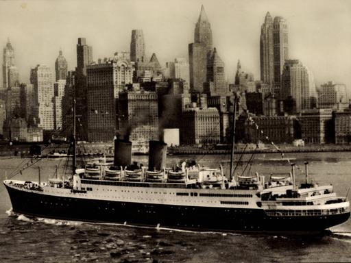 Historisches Schwarzweißfoto: Das Dampfschiff MS Berlin kreuzt vor der Silhouette New Yorks.