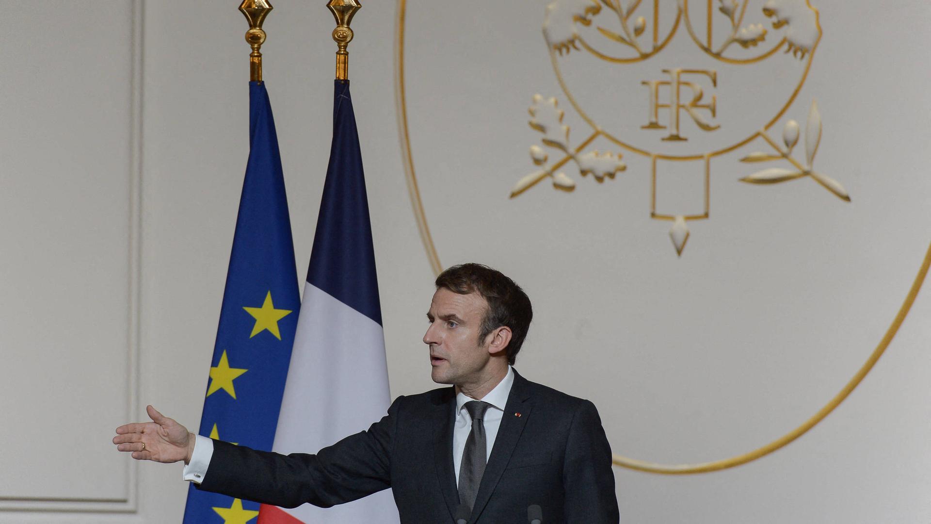 Der französische Präsident Macron hält eine Rede und zeigt mit seinem Arm nach links. Der französische Präsident Macron hält eine Rede und zeigt mit seinem Arm nach links.