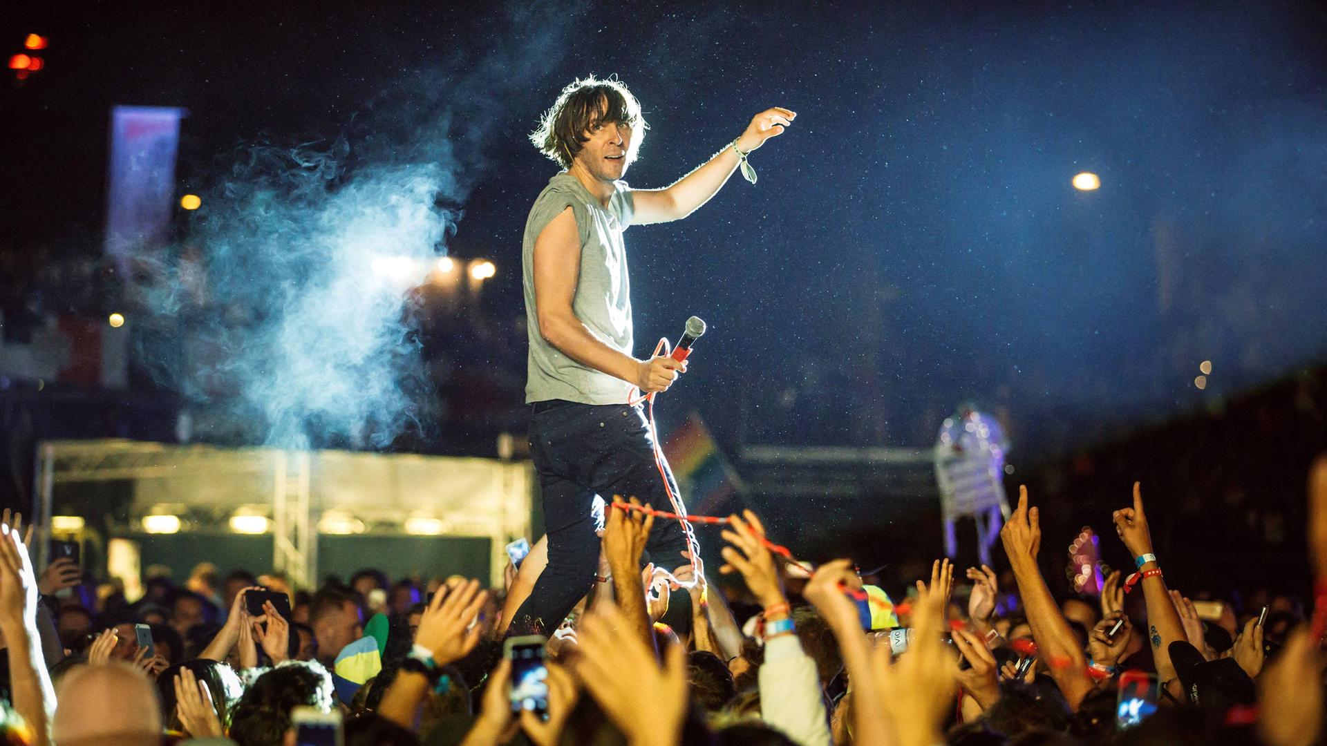 Die Band Phoenix mit ihrem Sänger Thomas Mars während eines Auftritts beim Melt! Festival im Juli 2017. Der Sänger steht auf einer erhöhten Bühne und ist umgeben von jubelnden Konzertbesuchern, die die Arme emporstrecken. Die Band Phoenix mit ihrem Sänger Thomas Mars während eines Auftritts beim Melt! Festival im Juli 2017. Der Sänger steht auf einer erhöhten Bühne und ist umgeben von jubelnden Konzertbesuchern, die die Arme emporstrecken.