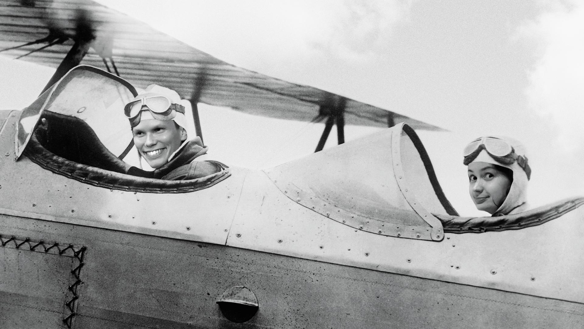 Ein Mann und eine Frau sitzen in einem Segelflugzeug alten Typs. Ein Mann und eine Frau sitzen in einem Segelflugzeug alten Typs.