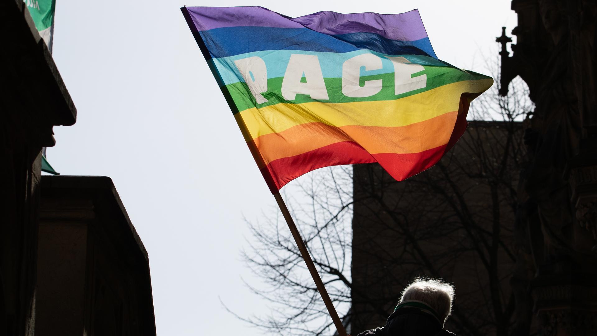 Ein Friedensaktivist in Osnabrück schwenkt eine Friedensfahne in Regenbogenfarben. Ein Friedensaktivist in Osnabrück schwenkt eine Friedensfahne in Regenbogenfarben.