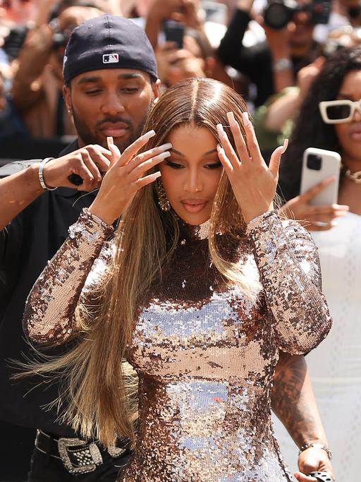 Cardi B tritt bei der Pariser Fashion Week auf. Im Hintergrund wird sie von mehreren Menschen mit der Handykamera abgelichtet. 