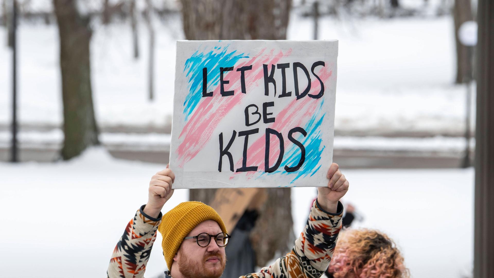 Demonstrant in Minnesota, USA, mit einem Schild "Let Kids be Kids" bei einer Demonstation für die Rechte von Trans-Jugendlichen Demonstrant in Minnesota, USA, mit einem Schild "Let Kids be Kids" bei einer Demonstation für die Rechte von Trans-Jugendlichen