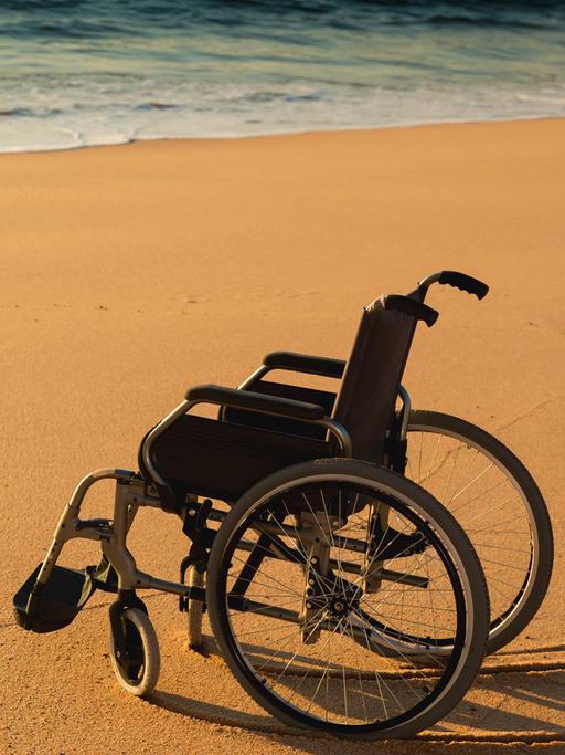 Verliert ein eingeschränktes Leben seinen Wert?  Zu sehen: Ein Rollstuhl an einem Sandstrand am Meer. 