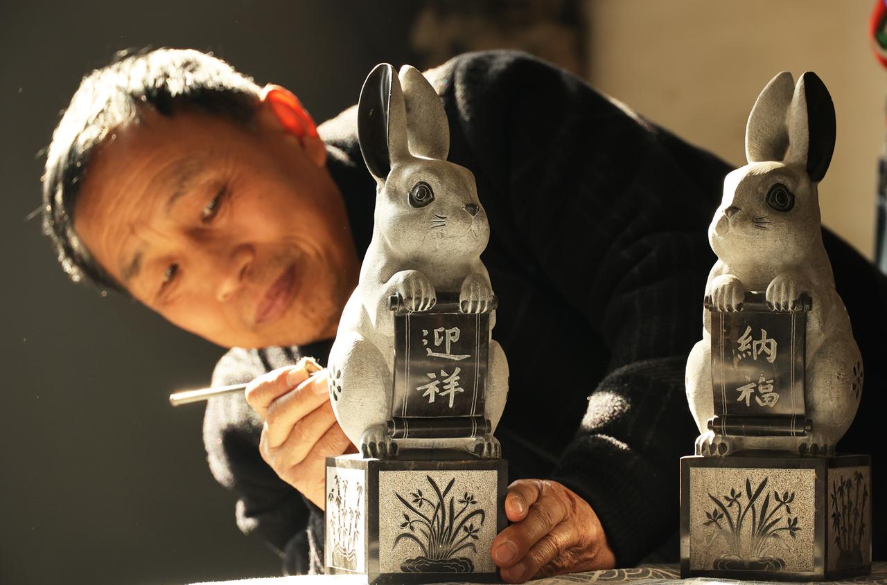 Ein Handwerker in Yuncheng in der chinesischen Provinz Shanxi arbeitet an in Stein gehauenen Hasenskulpturen, um das chinesische Neujahr zum Jahr des Hasen zu begrüßen. Ein Handwerker in Yuncheng in der chinesischen Provinz Shanxi arbeitet an in Stein gehauenen Hasenskulpturen, um das chinesische Neujahr zum Jahr des Hasen zu begrüßen.