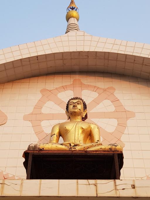 An der Fassade des Tempels "Bhogal Buddha Vihar" in Delhi thront eine Buddha-Figur.