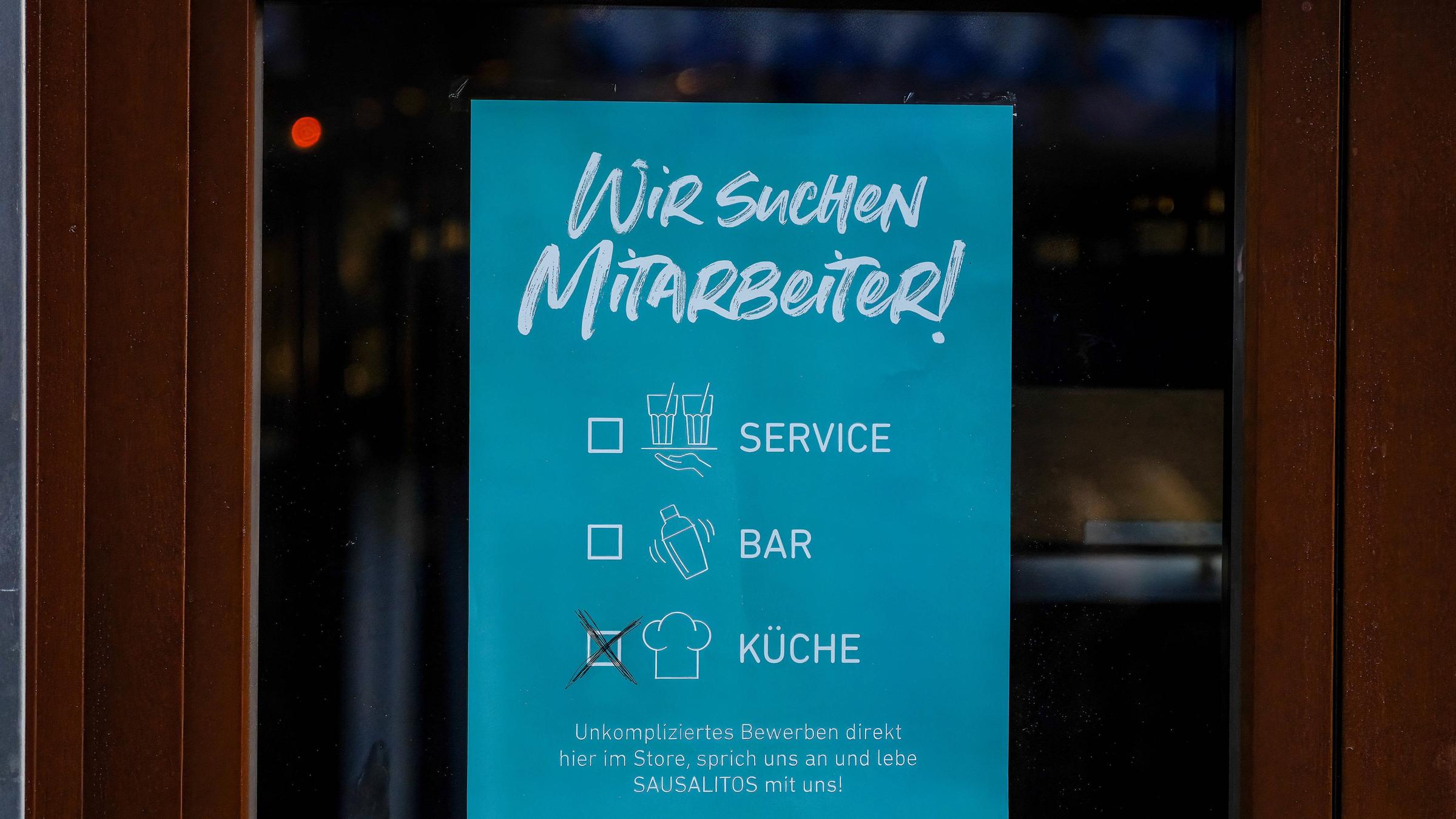 Poster an einer Glastür, auf dem steht, dass ein Koch als Mitarbeiter gesucht wird Poster an einer Glastür, auf dem steht, dass ein Koch als Mitarbeiter gesucht wird