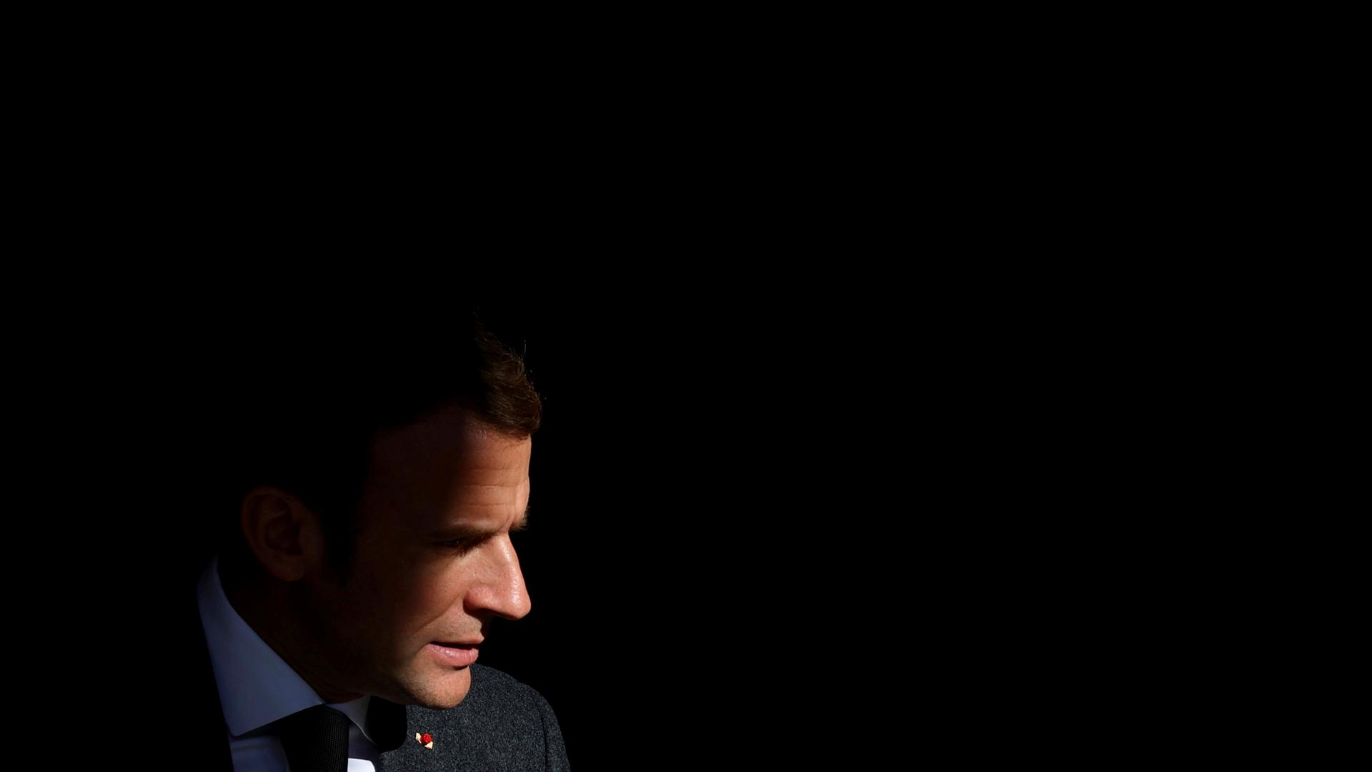 Frankreichs Präsident Emmanuel Macron im Profil vor dunkelm Hintergrund
