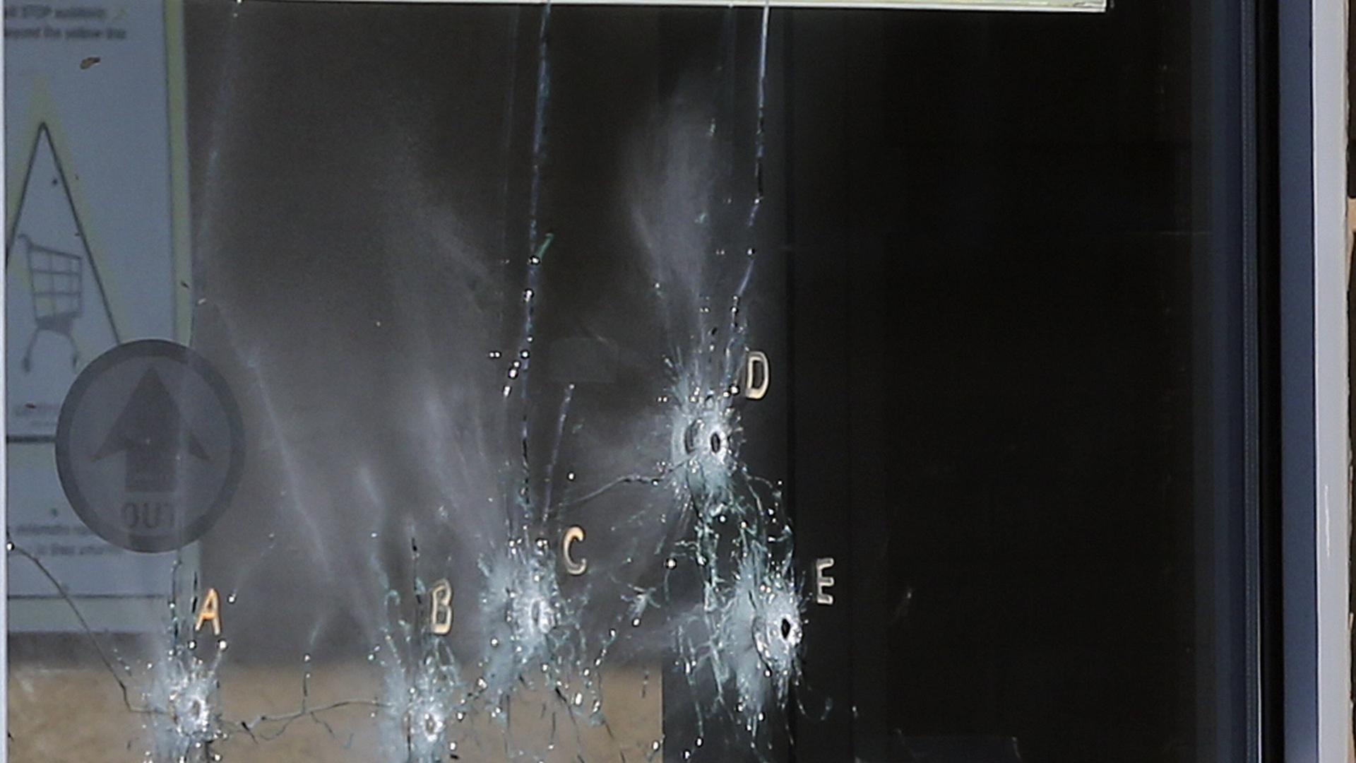 Einschusslöcher in der Scheibe eines Supermarktfensters in Buffalo nach einem rechtsextremen Attentat Einschusslöcher in der Scheibe eines Supermarktfensters in Buffalo nach einem rechtsextremen Attentat