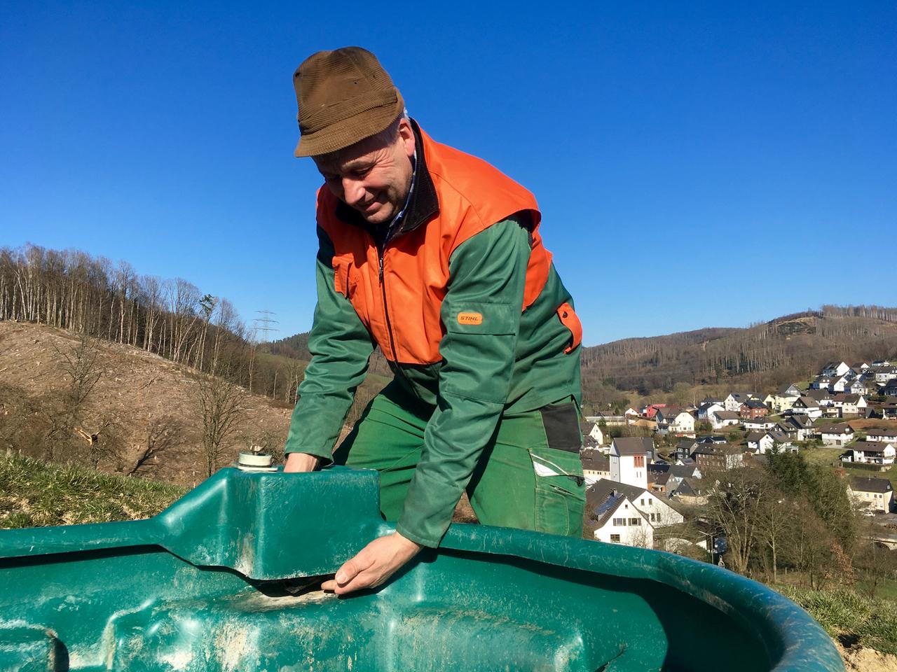 Ein Bauer repariert eine Kuhtränke. Ein Bauer repariert eine Kuhtränke.