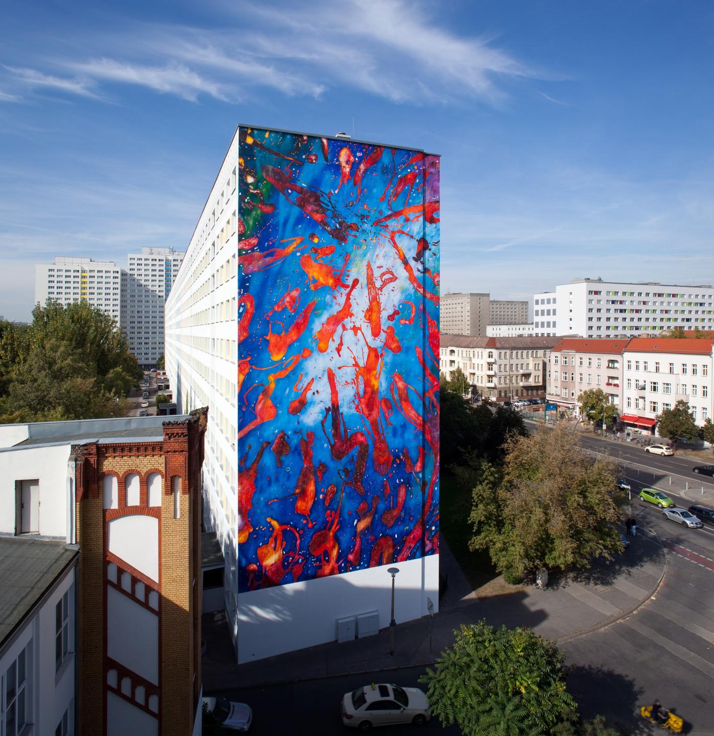 Die Fassade eines Hauses in Berlin-Lichtenberg. Man sieht riesige rote Farbspritzer auf blauem Grund. Die Fassade eines Hauses in Berlin-Lichtenberg. Man sieht riesige rote Farbspritzer auf blauem Grund.