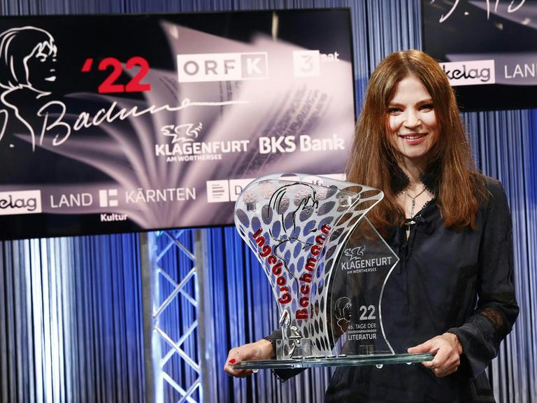 Bachmann-Preisgewinnerin Ana Marwan steht mit der Gewinnertrophäe auf der Bühne in Klagenfurt
