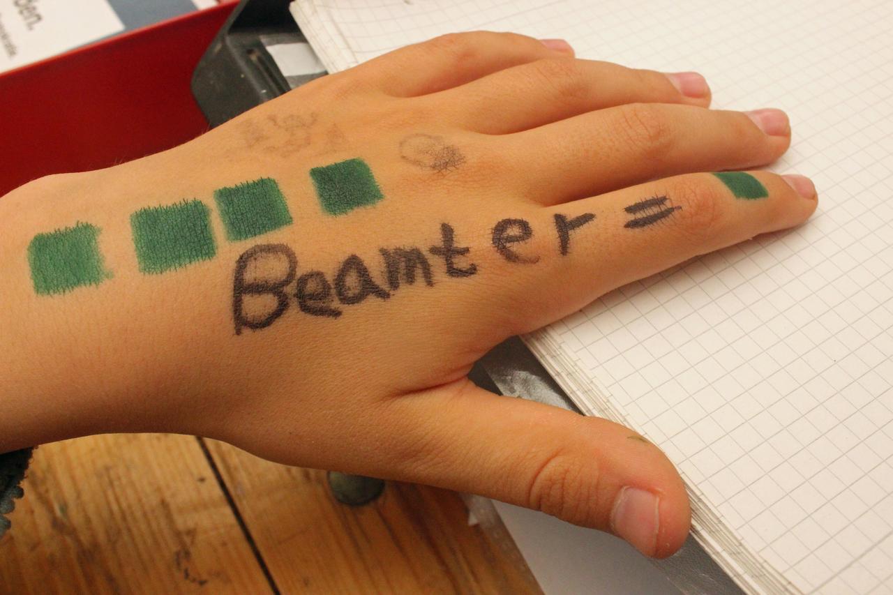 Kinderhand, auf der "Beamter" geschrieben steht Kinderhand, auf der "Beamter" geschrieben steht