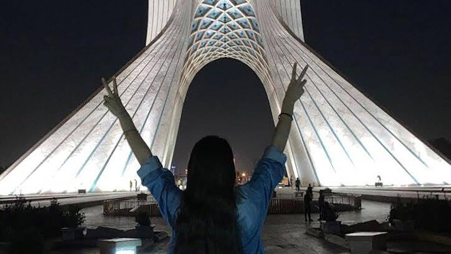 Eine junge Frau ohne Hijab mit offenen Haaren macht das Victoryzeichen mit ihren beiden Händen vor dem Azadi Turm in Teheran, 17.November 2022. Eine junge Frau ohne Hijab mit offenen Haaren macht das Victoryzeichen mit ihren beiden Händen vor dem Azadi Turm in Teheran, 17.November 2022.