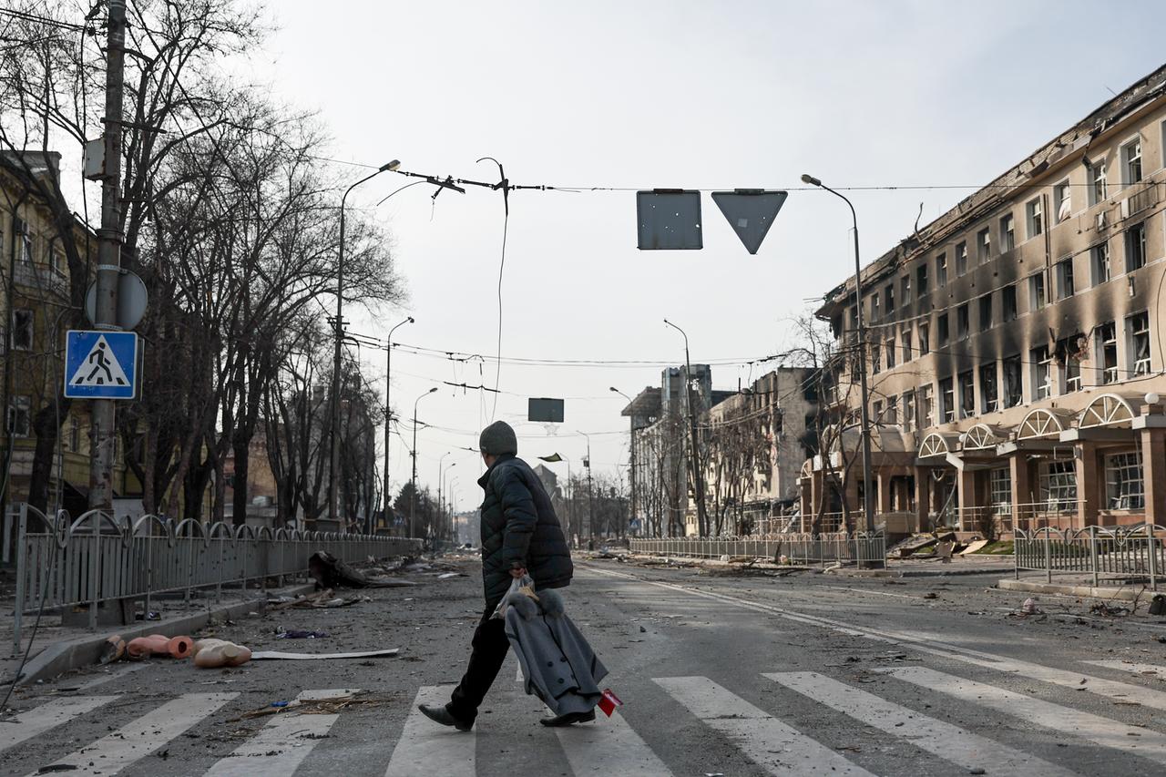 Ein Mann überquert eine Straße in der umkämpften ukrainischen Stadt Mariupol 