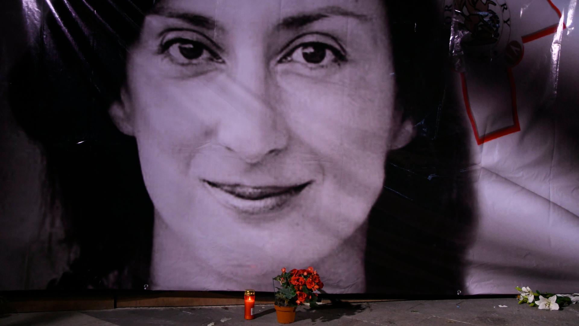 An einer Wand aufgestelltes Foto von Daphne Caruana Galizia An einer Wand aufgestelltes Foto von Daphne Caruana Galizia