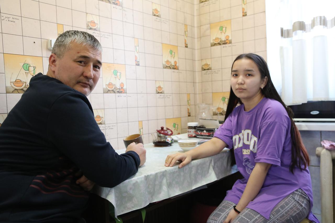 Aidos Meldekhanuly mit Tochter sitzend am Küchentisch