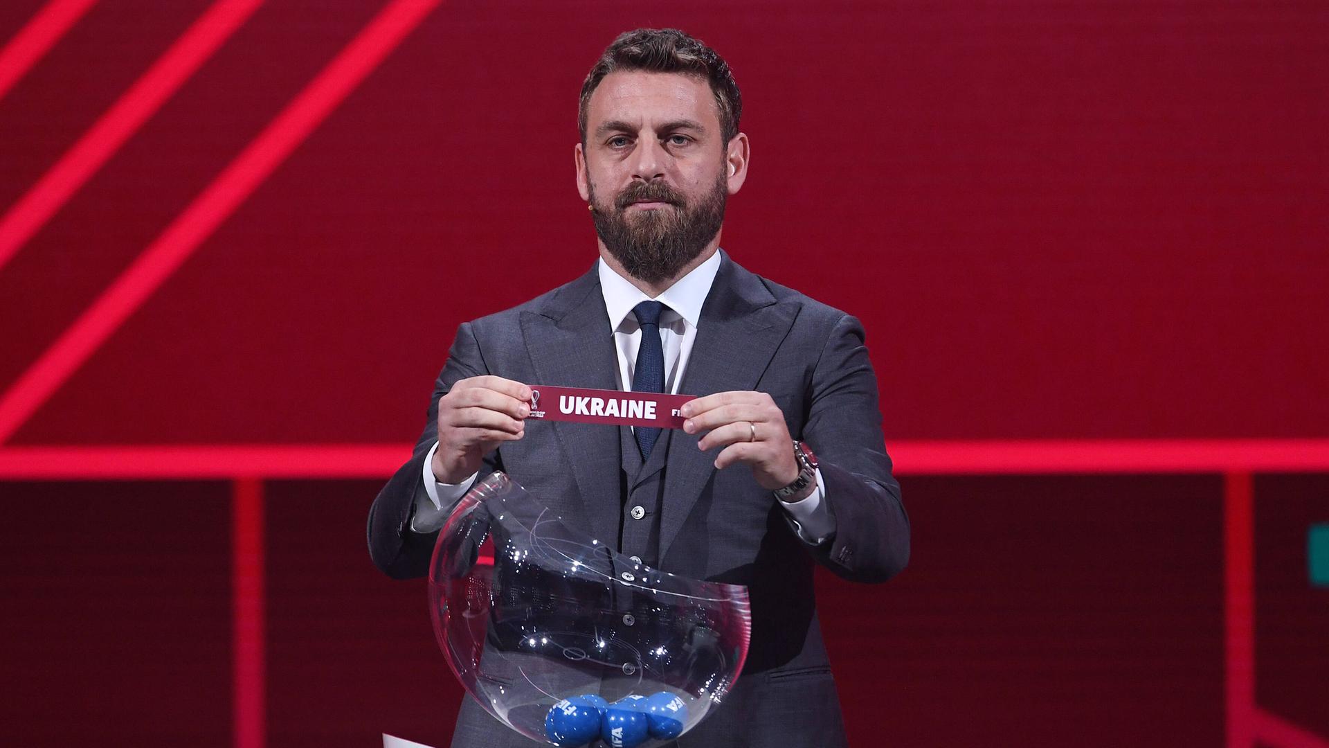 Ex-Fußballer Daniele de Rossi zieht bei der Auslosung der WM-Qualifikation das Los Ukraine aus einem Lostopf.