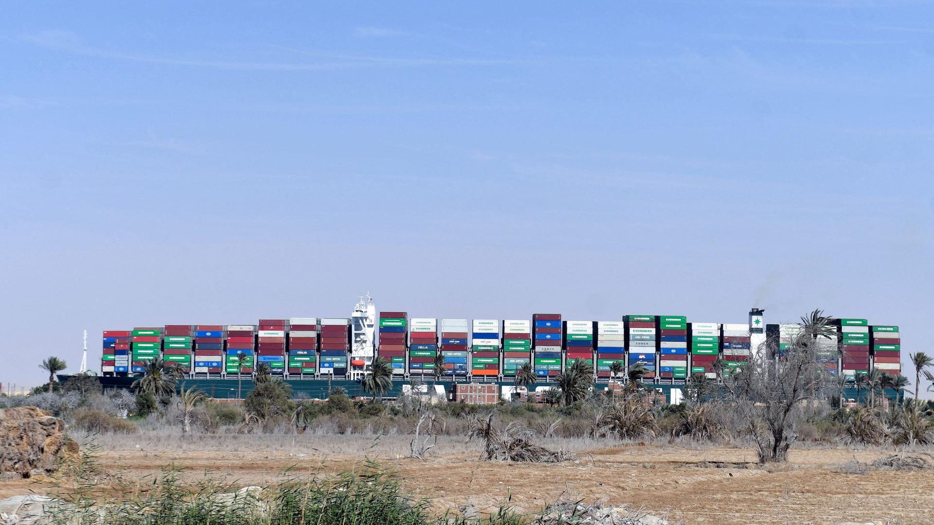 Das Containerschiff "Ever Given", das im März 2021 Suezkanal steckengeblieben war, vom Ufer aus betrachtet Das Containerschiff "Ever Given", das im März 2021 Suezkanal steckengeblieben war, vom Ufer aus betrachtet