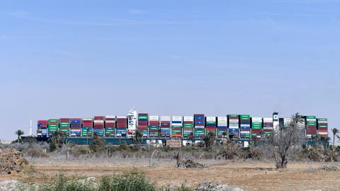 Das Containerschiff "Ever Given", das im März 2021 Suezkanal steckengeblieben war, vom Ufer aus betrachtet