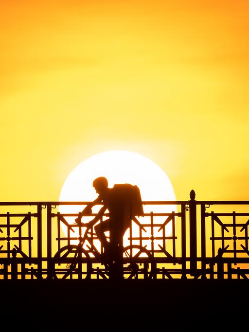 Der Fahrer eines Lieferdiensts fährt über die Theodor-Heuss-Brücke.