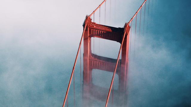 Unterwegs nach San Francisco muss van Dusen einen kühlen Kopf bewahren. Zu sehen: Ein Pfeiler der Golden Gate Bridge von oben in Wolken gehüllt. 