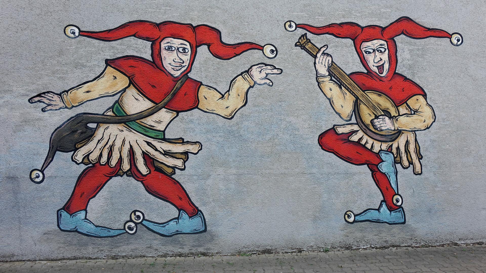 Zwei Hofnarren sind als Graffiti an einer Wand angebracht. Zwei Hofnarren sind als Graffiti an einer Wand angebracht.