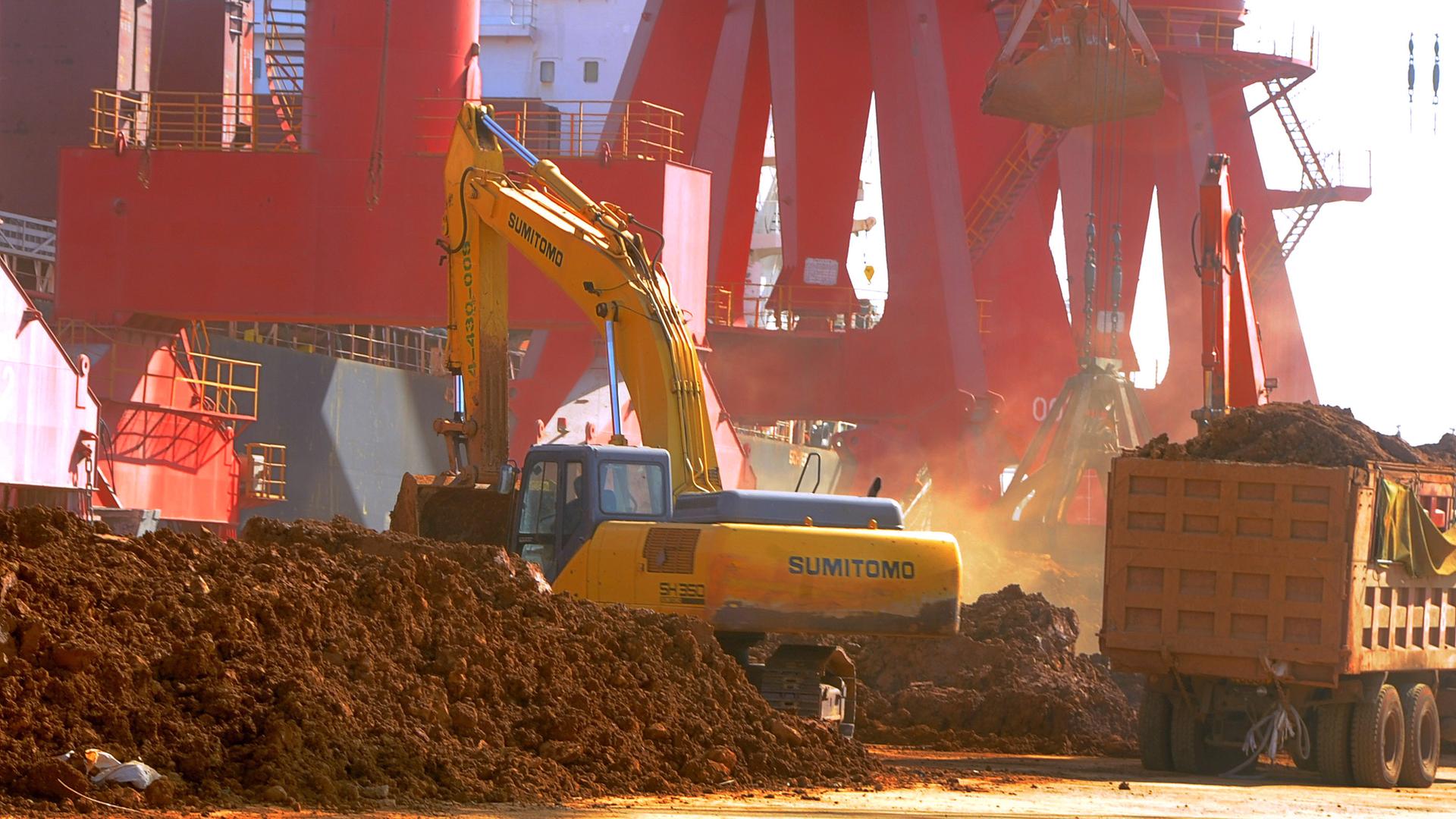 Ein Bagger lädt im Hafen von Lianyungang in China seltene Erden auf einen Lastwagen Ein Bagger lädt im Hafen von Lianyungang in China seltene Erden auf einen Lastwagen