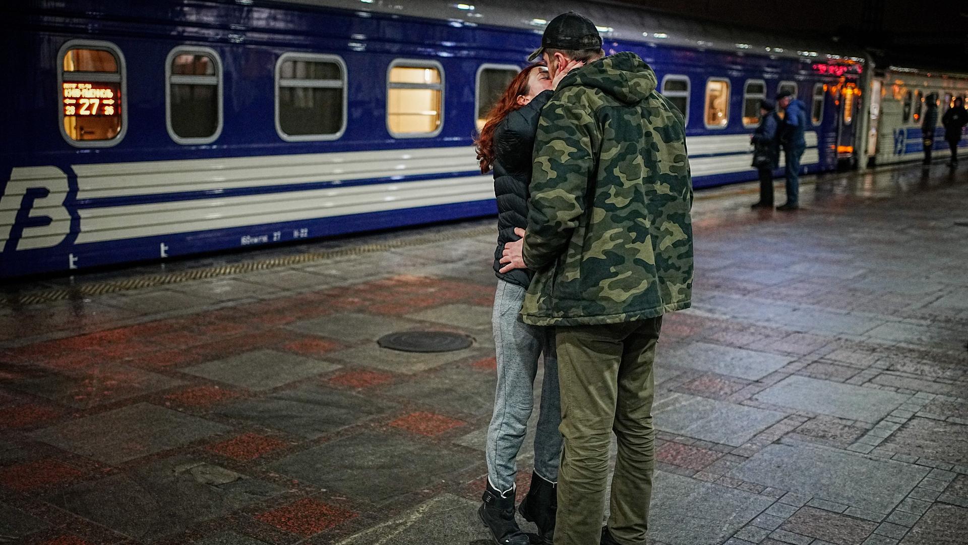 Ein Paar verabschiedet sich am Hauptbahnhof von Kiew. Von hier fährt der Nachtzug in die polnische Grenzstadt Przemysl. Männer dürfen das Land wegen des Krieges nur sehr eingeschränkt verlassen.