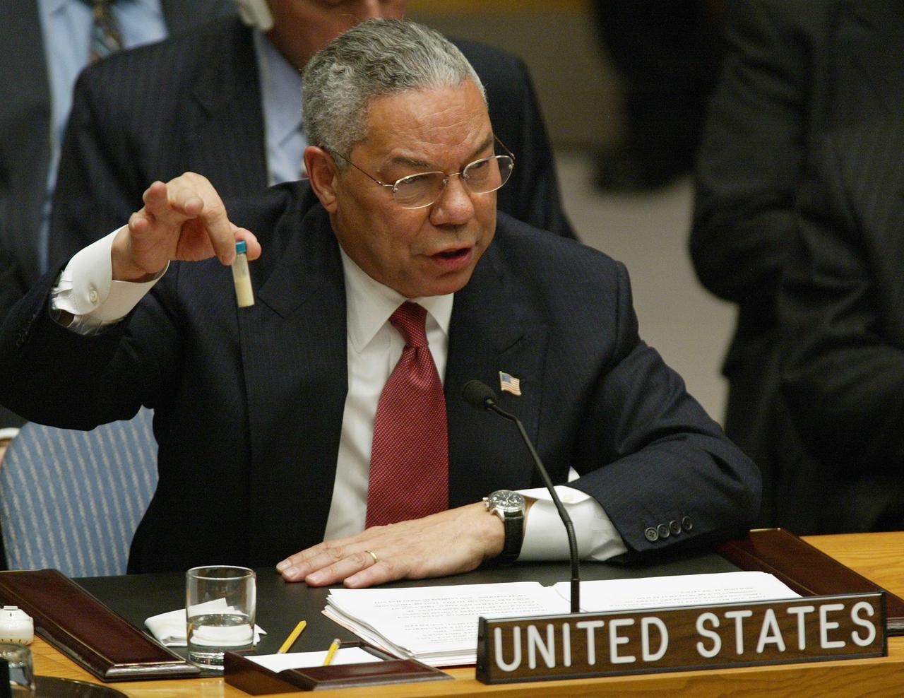 US-Außenminister Colin Powell sitzt im UN-Sicherheitsrat und hält eine kleines Fläschchen mit einer Substanz hoch.