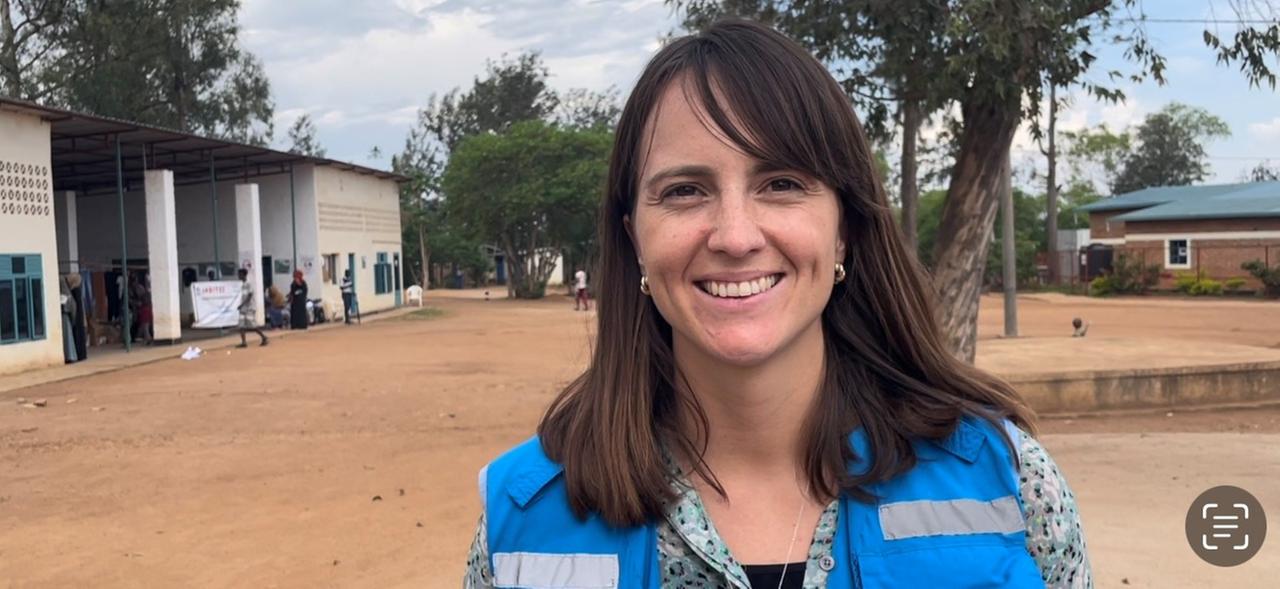 Eine Frau mit braunen Haaren schaut lächelnd in die Kamera: Lilly Carlisle, UNHCR. Eine Frau mit braunen Haaren schaut lächelnd in die Kamera: Lilly Carlisle, UNHCR.