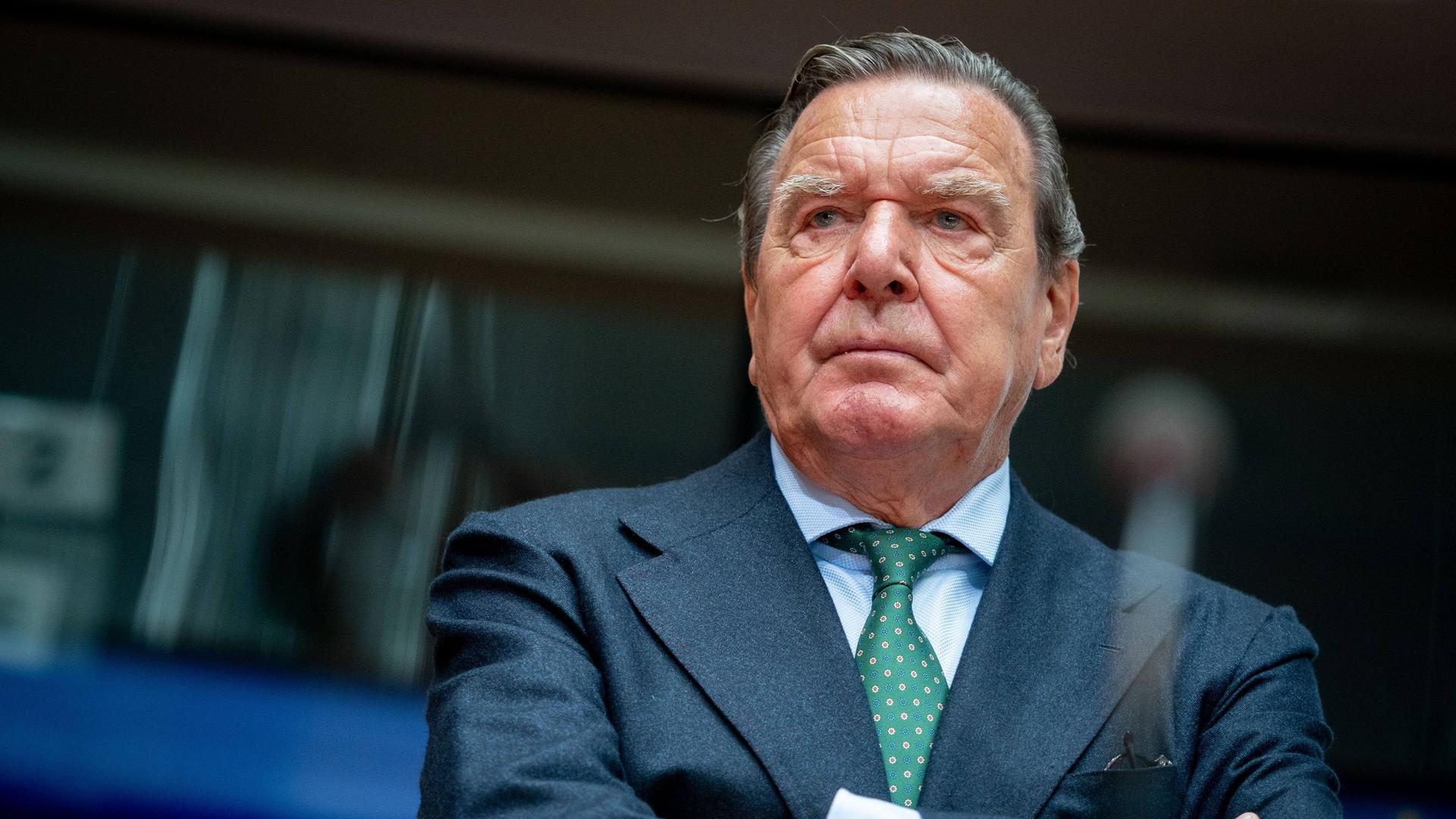 Gerhard Schröder (SPD), ehemaliger Bundeskanzler im Anzug mit verschränkten Armen in einem Sitzungsaal des Bundestages. Gerhard Schröder (SPD), ehemaliger Bundeskanzler im Anzug mit verschränkten Armen in einem Sitzungsaal des Bundestages.