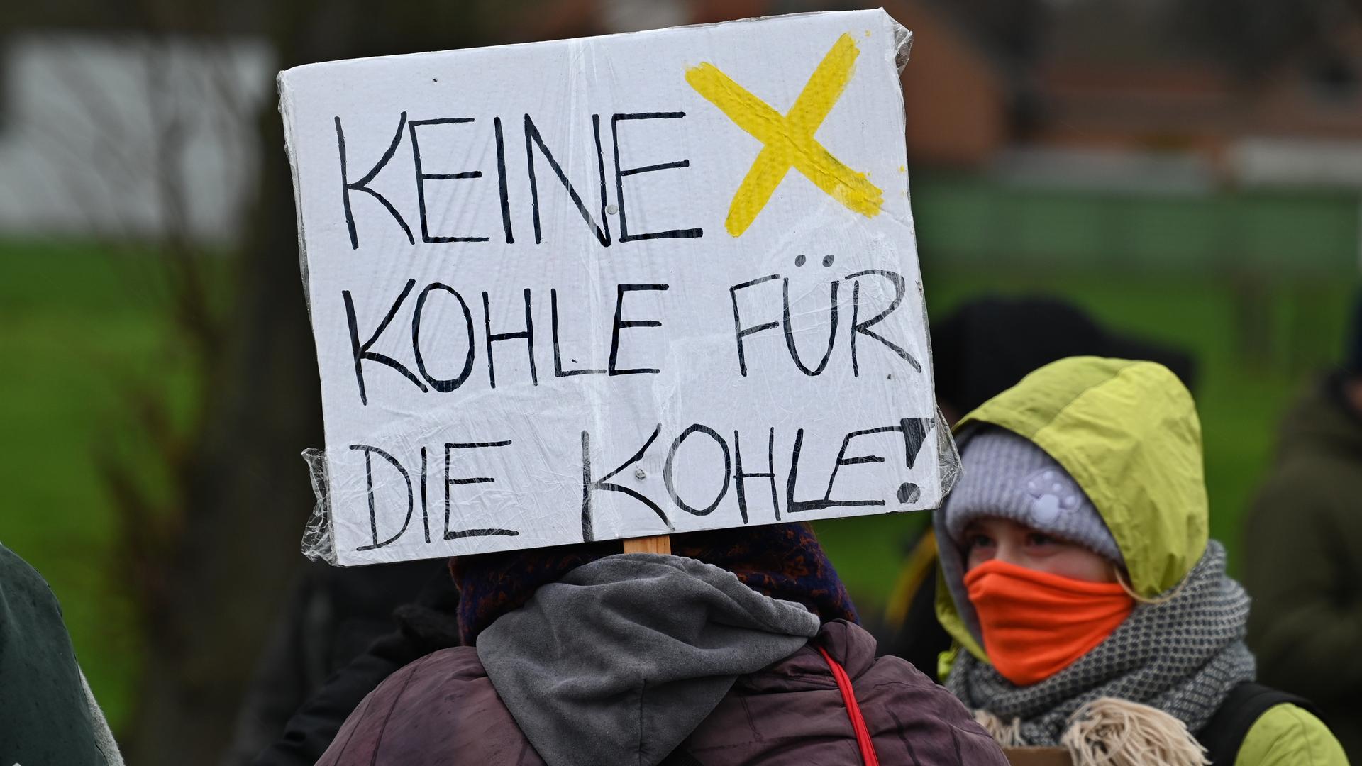 Demonstranten halten ein Schild mit der Aufschrift "Keine Kohle für die Kohle" auf einer Demonstration am 14.01.2023 bei Lützerath hoch Demonstranten halten ein Schild mit der Aufschrift "Keine Kohle für die Kohle" auf einer Demonstration am 14.01.2023 bei Lützerath hoch