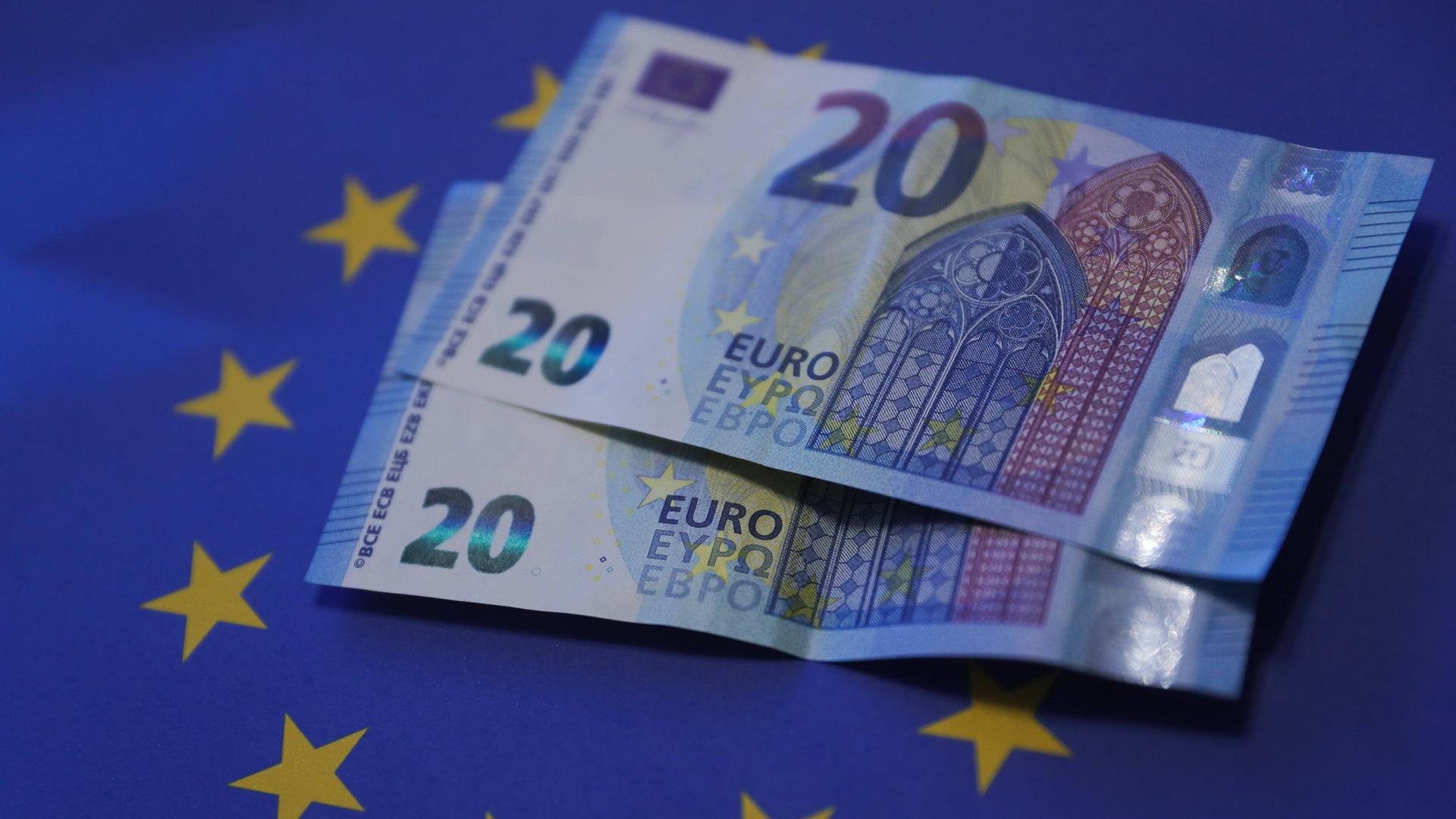 20-Euro-Geldscheine auf einer Europaflagge. Vor 20 Jahren wurde der Euro als Bargeld eingeführt 20-Euro-Geldscheine auf einer Europaflagge. Vor 20 Jahren wurde der Euro als Bargeld eingeführt