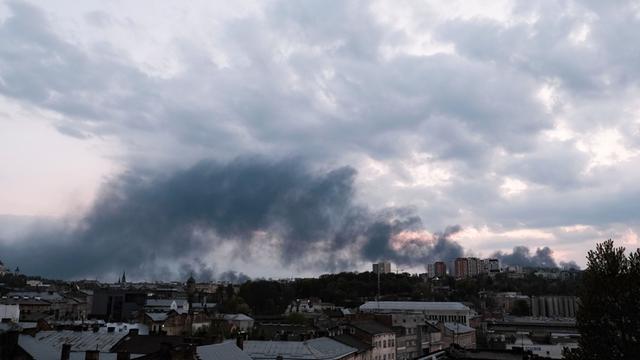 Ukraine, Lwiw: Rauchschwaden ziehen aus Richtung des Lemberger Bahnhofs über Lwiw (Lemberg), nachdem drei russische Raketen in Umspannwerke der Stadt eingeschlagen sind.