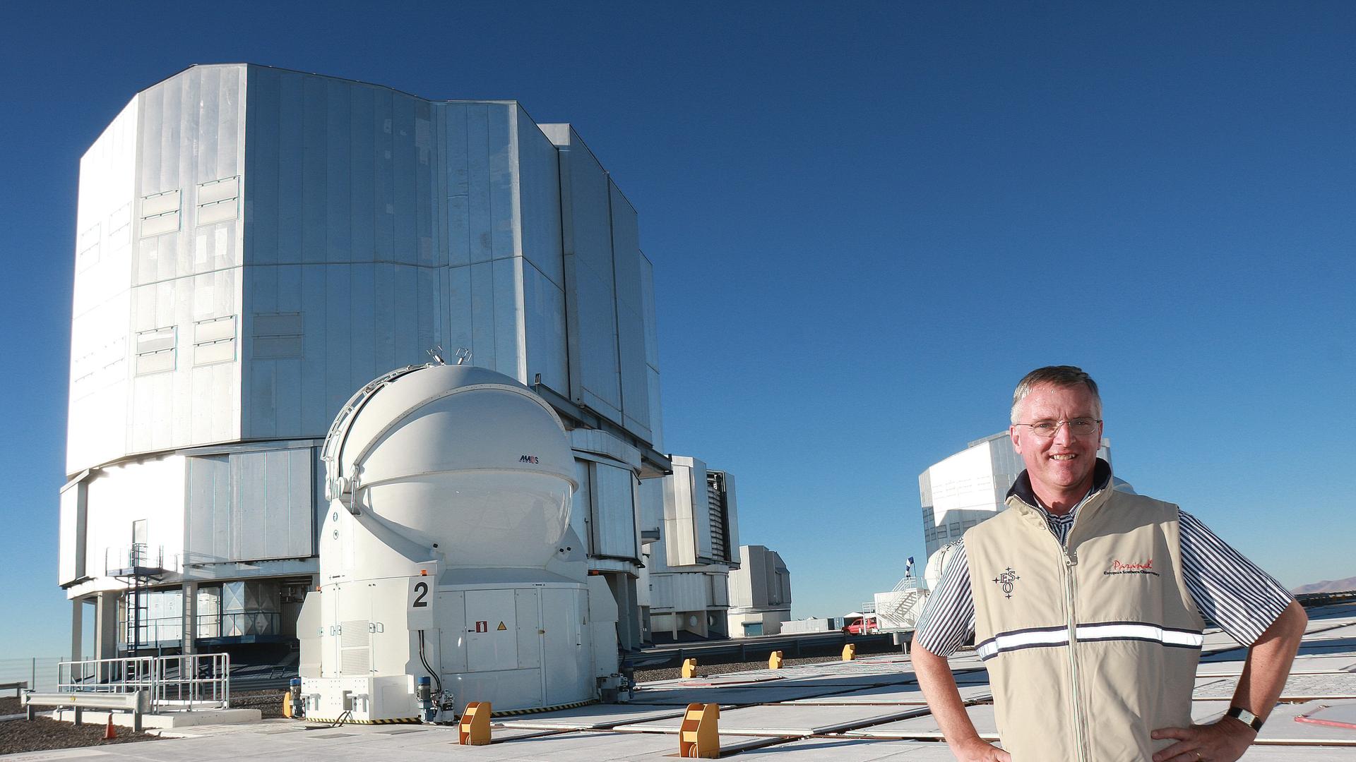 Professor Tim de Zeeuw, ESO Director General since September 2007, during a visit to the Paranal Observatory in August 2008. He stands on top of the Very Large Telescope platform in front of the enclosures of the four 8.2m unit telescopes ANTU, KUEYEN, MELIPAL, and YEPUN (from left to right). On the left the dome of AT2, one of the auxiliary telescopes, is seen.