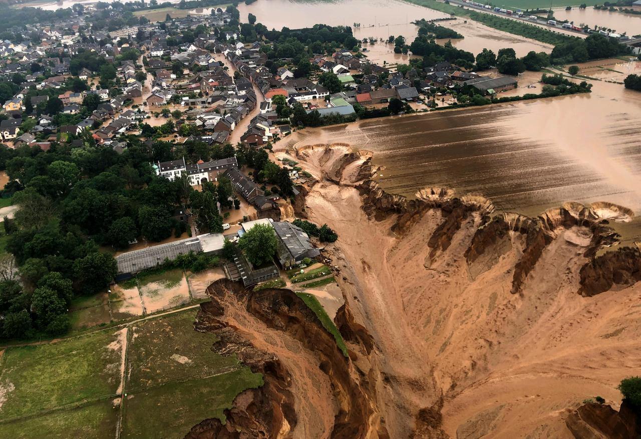 Das Foto zeigt die Ortschaft Erftstadt-Blessem zwei Tage nach der Flutkatastrophe vom Juli 2021. Im Vordergrund ist ein gewaltiger Krater, dicht an der Abbruchkante stehen erste Häuser des Ortes, andere sind in dem Krater versunken. Das Foto zeigt die Ortschaft Erftstadt-Blessem zwei Tage nach der Flutkatastrophe vom Juli 2021. Im Vordergrund ist ein gewaltiger Krater, dicht an der Abbruchkante stehen erste Häuser des Ortes, andere sind in dem Krater versunken.