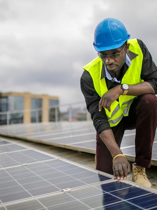 Ein Mitarbeiter prüft Solarpanels auf dem Dach einer Ausbildungseinrichtung für Solartechniker und Energieauditoren an der Strathmore University, Nairobi.