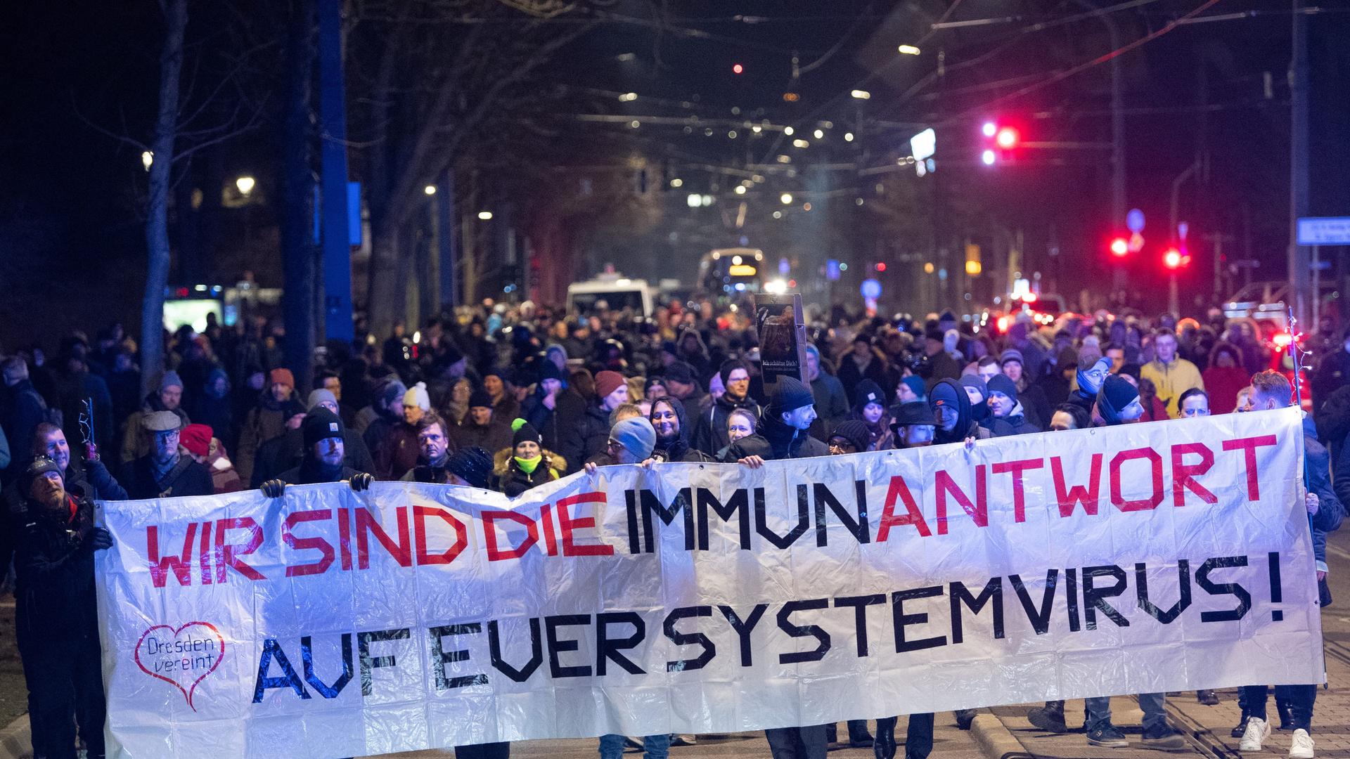 Teilnehmer einer Demonstration gegen die Corona-Maßnahmen in Dresden halten ein Transparent mit der Aufschrift "Wir sind die Immunantwort auf euer Systemvirus". Teilnehmer einer Demonstration gegen die Corona-Maßnahmen in Dresden halten ein Transparent mit der Aufschrift "Wir sind die Immunantwort auf euer Systemvirus".